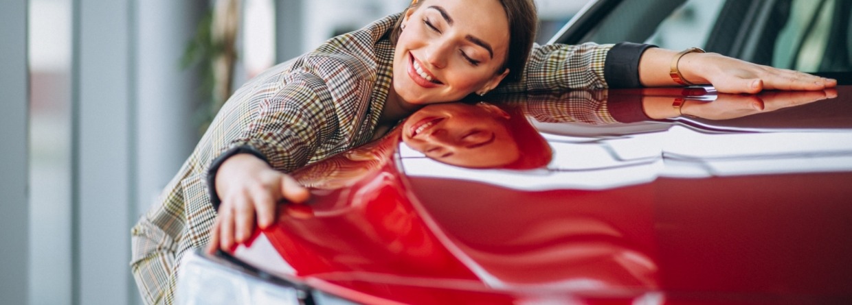 vrouw omarmt haar rode auto liefdevol